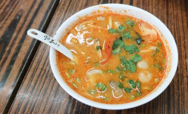 Tayland usulü baharatlı ve ekşi Tom Yum Gong çorbası karides, kalamar, baharat ve kişniş karışımı sokak satıcıları dükkanında kaşıkla servis edilir.