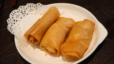 Karides ve domuz etiyle doldurulmuş üç Çin Dim Sum böreğini fotokopi uzayı ile birlikte beyaz bir tabağa koy.