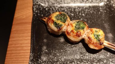 close up of Hong Kong style Grilled Quail Egg wrapped with pork skewer with spice on top and copy space