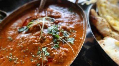 Hint köri sosunun yanında kişniş ve koyun etiyle süslenmiş portakallı köri ve yanında fotokopi alanı ile sarımsaklı ekmek servis edilir.