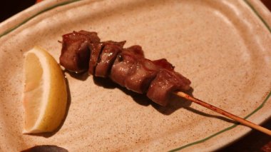 Japon ızgara tavuk sakatatı şiş yakın, sıklıkla bir dilim limonla fotokopi alanı olan bir Yakitori izakaya restoranında servis edilir.