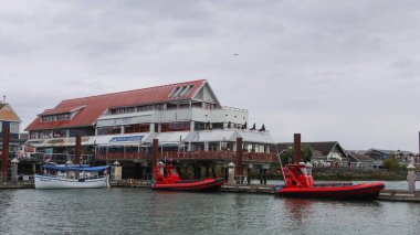 Blue Canoe Waterfront Restaurant, Steveston Village, Richmond, Vancouver, British Columbia, Kanada - 1 Ekim 2025: Kırmızı çatılı marina, rıhtıma yanaşmış tur botları