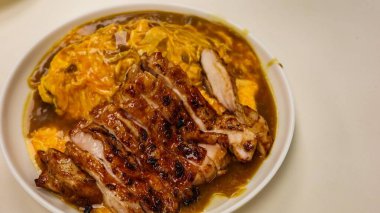 Japon körili pilavını çırpılmış yumurta ve köri soslu ızgara tavuk filetosu ile fotokopi alanı ile kapat.