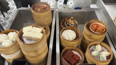 Kanton Dim Sum 'unu kırmızı tarih pastası, harr siu bao (çörek), harr gao ve pirinç rulolarını içeren dumanlı bambu budan bir buharlı buharlı tencereyle kapatın.