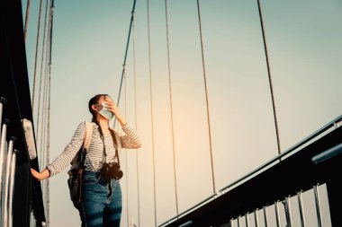Seyahat sırasında ve halka açık yerlerde maske takan yeni normal bir kız. Covid-19 konsepti kişisel bakım.