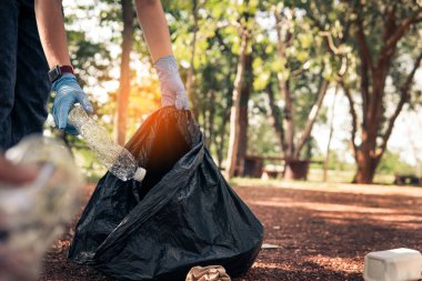 Plastik çöp taşıyan gönüllü atıkları düzgün bir şekilde atmak için temizler.