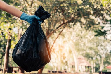 Plastik çöp taşıyan gönüllü atıkları düzgün bir şekilde atmak için temizler.