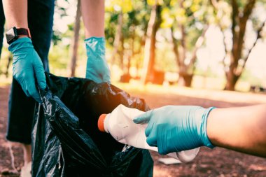 Plastik çöp taşıyan gönüllü atıkları düzgün bir şekilde atmak için temizler.