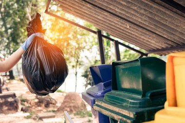 Plastik çöp taşıyan gönüllü atıkları düzgün bir şekilde atmak için temizler.