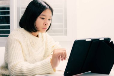 Ev okulunda Asyalı öğrenci çevrimiçi tecrit ve covid 19 salgınından öğreniyor..