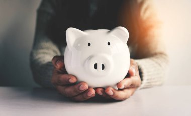 Beyaz kumbarayı elinde tutan kadın para tasarrufu kavramına. Bütçe, finansal....