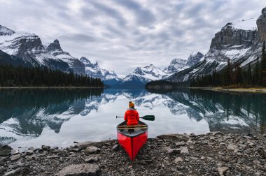 Yolcu, Maligne Gölü 'nde kanoyla oturuyor. Spirit Island, Jasper Ulusal Parkı, Kanada.