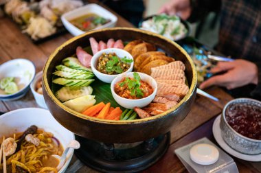 Kuzey Tayland yemeğinin aperatifleri kızarmış domuz, sosis, sebze ve Khantoke üzerine Tayland sosu sosu ya da restoranda geleneksel konteynır.