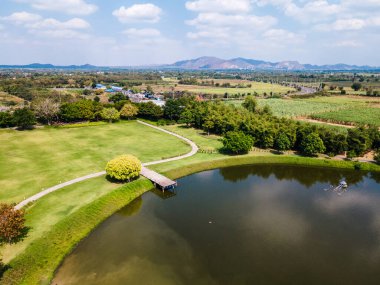 Göl kenarındaki ahşap iskele manzaralı yeşil çimenli ve mavi gökyüzü