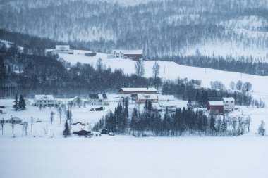 Nordland, Lofoten Adaları 'ndaki kar fırtınasında, kar tepesindeki Nordic ev köyü