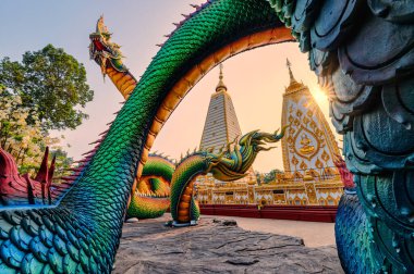 Gün batımında Wat Phra That Nong Bua, Ubon Ratchathani 'de Sri Maha Pho Chedi stupa' yı çevreleyen Gökkuşağı Yılan veya renkli Tayland Naga