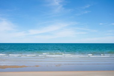 Kumsalda güzel mavi tropikal deniz ve güneşli bir günde parlak gökyüzü