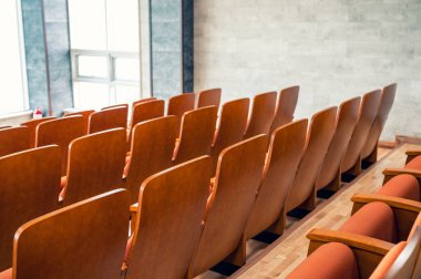 Salondaki kahverengi koltukların arkasında.