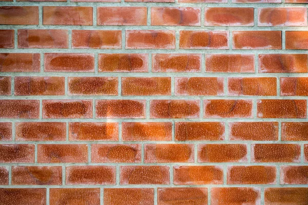 Weathered orange bricks block on cement wall. Vintage and retro background
