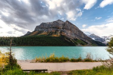 Kanada, Alberta 'daki Banff Ulusal Parkı' nda sonbaharda Rocky dağları ve turkuaz suyla Louise Gölü manzarası.