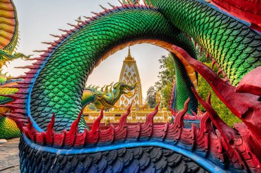 Gün batımında Wat Phra That Nong Bua, Ubon Ratchathani 'de Sri Maha Pho Chedi stupa' yı çevreleyen Gökkuşağı Yılan veya renkli Tayland Naga