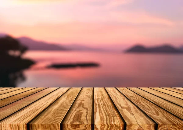 黄昏背景下 湖面上朦胧的五彩斑斓的天空上的木制桌子 — 图库照片