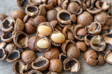 Ahşap masada soyulmuş organik Macadamia fındığı yığını.