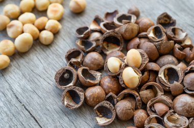 Ahşap masada soyulmuş organik Macadamia fındığı yığını.