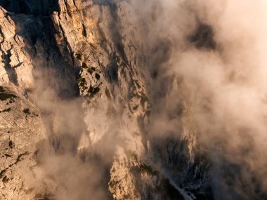 Trecime, Dolomites, İtalya 'da yoğun gündoğumu sisli engebeli dağ uçurumunun hava aracı görüntüsü