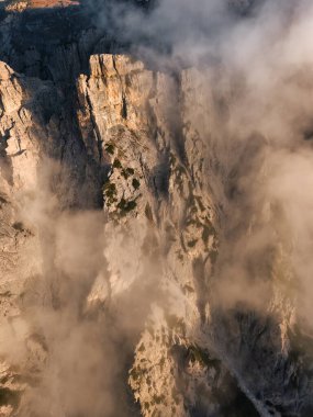 Trecime, Dolomites, İtalya 'da yoğun gündoğumu sisli engebeli dağ uçurumunun hava aracı görüntüsü