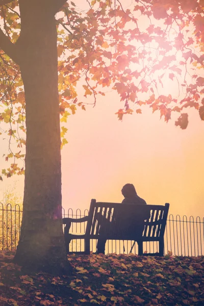 Человек, сидящий один на скамейке — стоковое фото