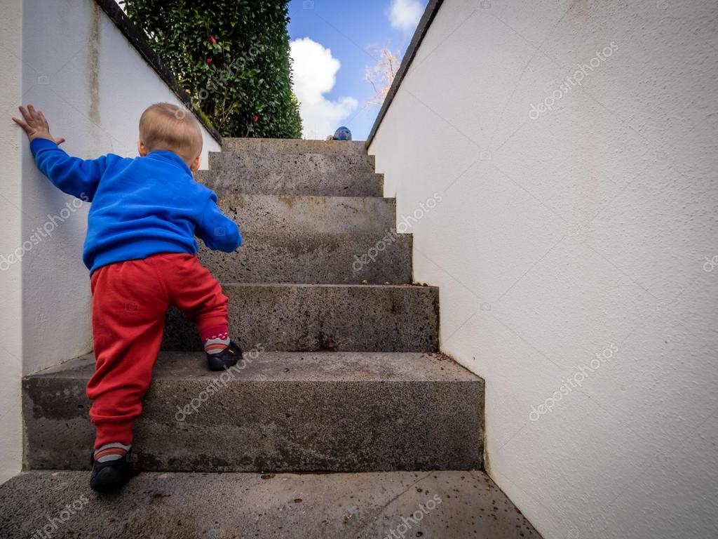 На ступеньку вскакивает хлопчик. Лестница для детей. Карабкаться по лестнице. Ребенок по ступенькам. Мальчик на лестнице.