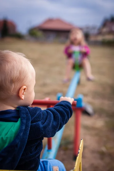 Boy and girl on a swing — Stock Photo, Image