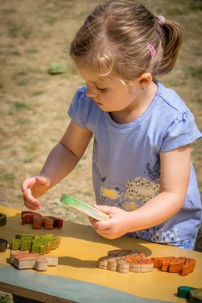 A kislány a fából készült puzzle játék — Stock Fotó