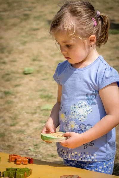 Menina brincando com o quebra-cabeça de madeira — Fotografia de Stock