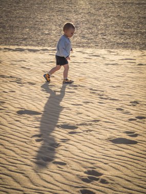 Küçük çocuk kum tepeleri üzerinde yürüme