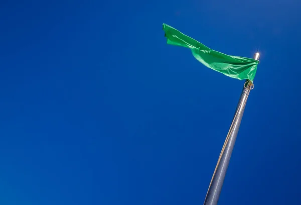 Grüne Fahne flattert im Wind — Stockfoto