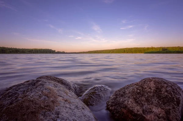 黄昏的时候 背景上的小石块淹没在湖中的湖中 — 图库照片