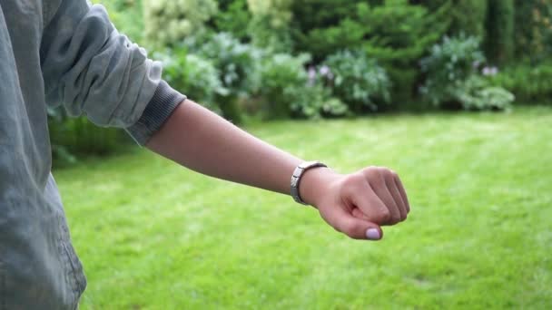 Virtual display on a wristwatch. Young girl looks at the data of the smartphone. — Vídeos de Stock