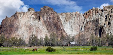 Oregon 'daki Smith Rock üssünde bir köy ahırı var. Bir at sessizce tarlada otlar..