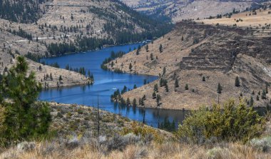 Oregon 'daki Billy Chinook Gölü' nün Metolius Kolu 'nun birçok kıvrımında tekne hızlanır. Yol gölün üstünde görülebilir..