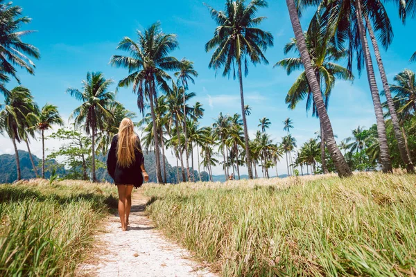 Rear view of a beautiful young woman surrounded by tropical landscape — Stock Photo, Image