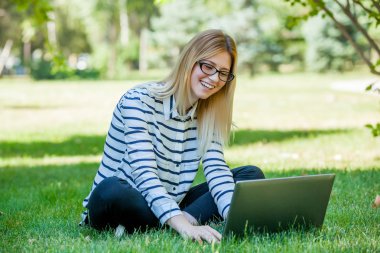 Öğrenci Park çim üstünde laptop ile