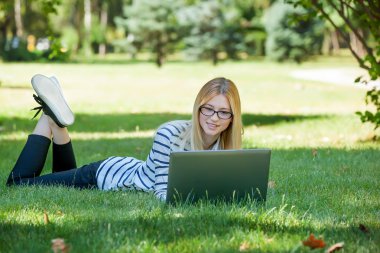 Öğrenci Park çim üstünde laptop ile