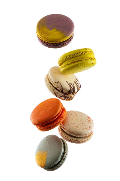 Beyaz arka planda izole edilmiş uçan renkli badem kurabiyeleri ya da pastalar havada asılı duruyor. Tatlı ve renkli tatlı Kopya Uzay Renkli Fransız kurabiyeleri