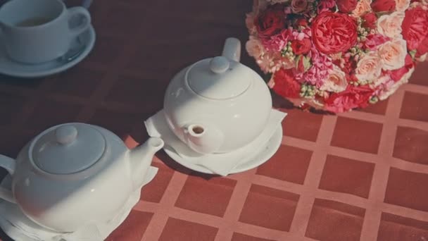 Tee aus einer Teekanne in die Tasse gegossen, Hände — Stockvideo