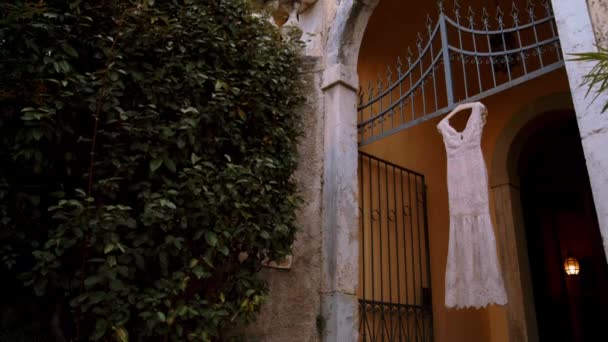 A  wedding dress hanging on the door of the villa — Stock Video