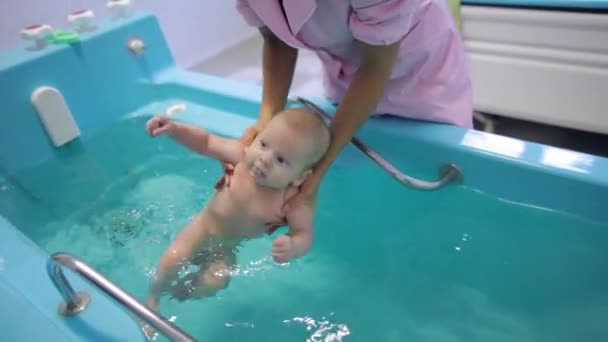 El bebé aprende a nadar en la bañera — Vídeos de Stock