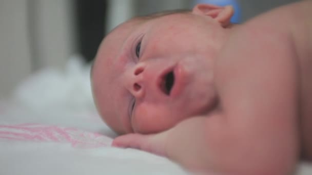 Le bébé se couche sur le ventre et bâille — Video