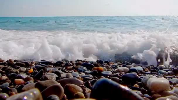 Küçük çakıl taşları ve deniz sörf ile çakıl plajı. Bir vahşi çakıl plajı deniz yüzeyi. Dalgalar için kamera vardır. Görünüm su altında. Dalga köpüğü. — Stok video